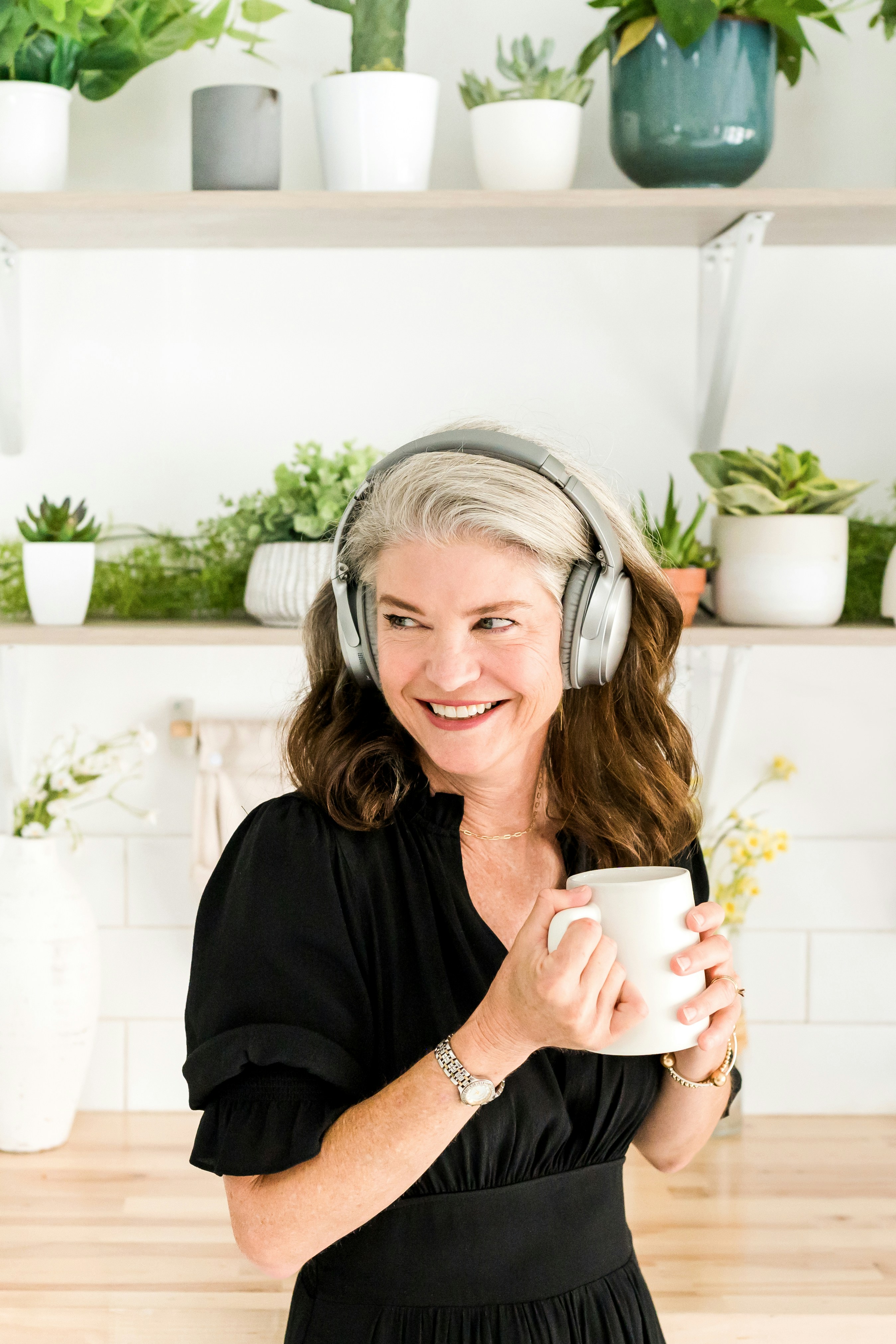 Woman with headphones on holding a cup